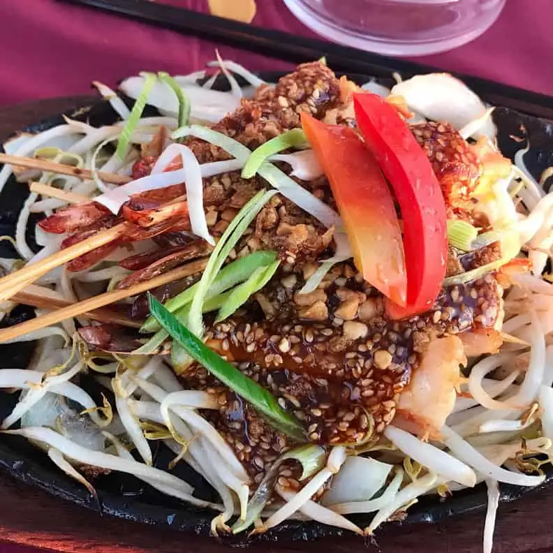 Plat sauté au sésame servi sur plaque chauffante